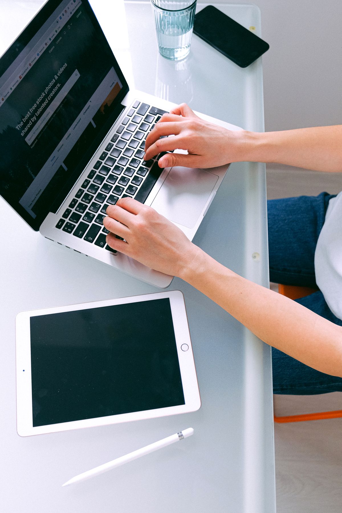Remote worker reviewing financial documents on laptop at desk