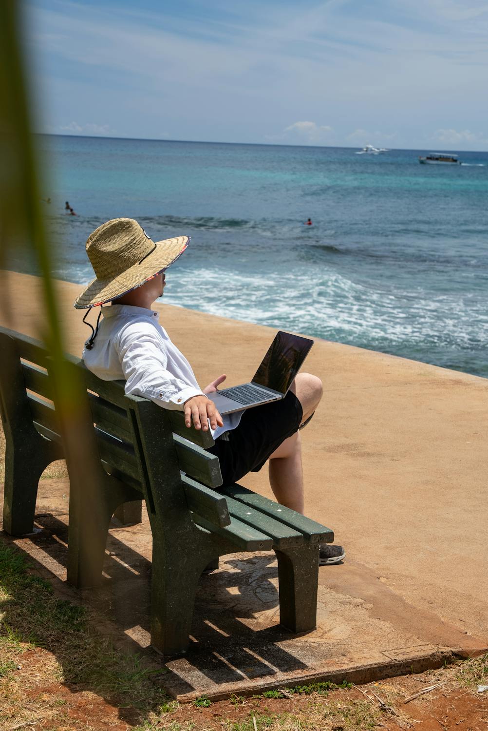 Person working on a laptop by the sea, embodying the digital nomad lifestyle