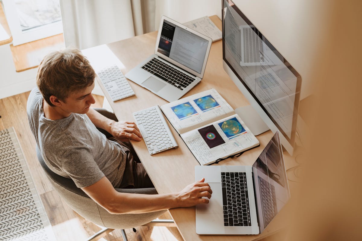 Developer working on multiple monitors with code — remote AI job setup