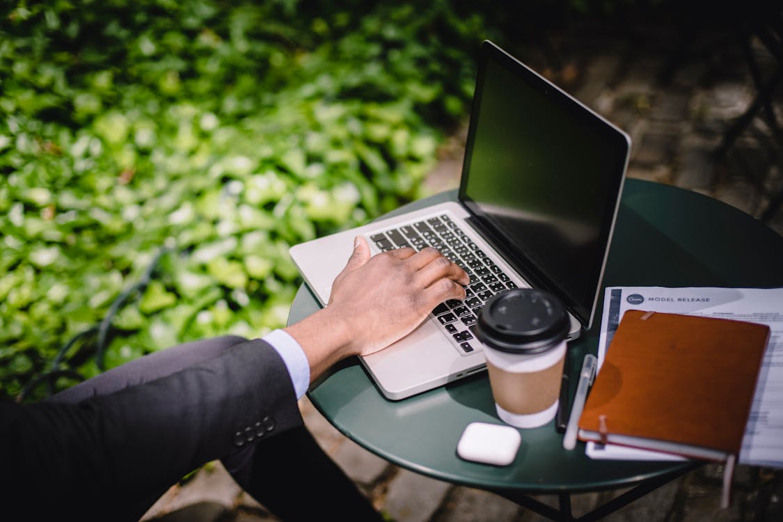Remote professional working from a cafe with laptop and coffee, representing the digital nomad lifestyle